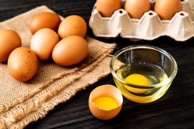 Ahşap masa üzerinde yumurta ile bir kırık kahverengi ve yumurta sarısı