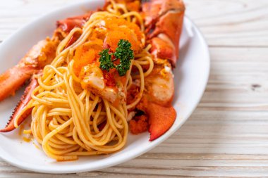 Beyaz tabakta karides yumurtalı ıstakoz spagettisi.