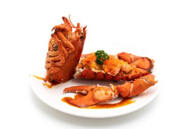 Soslu ıstakoz kuyruklu biftek ve beyaz arka planda karides yumurtaları.