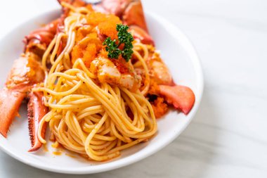 Beyaz tabakta karides yumurtalı ıstakoz spagettisi.