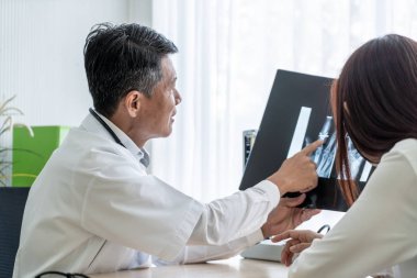 Asyalı doktor ve hasta röntgen film Office ile görüşüyorlar