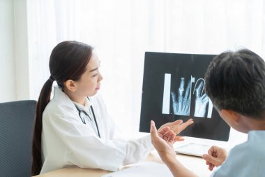 Asyalı kadın doktor ve hasta masada - seçici otururken bir şey tartışırken noktaya odaklama