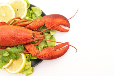 Beyaz arka planda taze haşlanmış sebze ve limonlu ıstakoz.