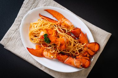 Beyaz tabakta karides yumurtalı ıstakoz spagettisi.