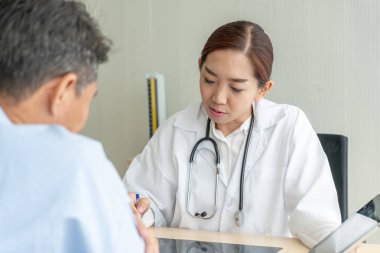 Asyalı kadın doktor ve hasta masada - seçici otururken bir şey tartışırken noktaya odaklama