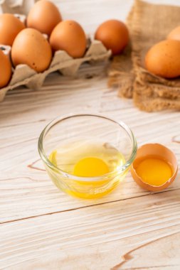 Ahşap masa üzerinde yumurta ile bir kırık kahverengi ve yumurta sarısı