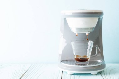 Kahve makinesi ahşap arka planda kahve yapıyor.