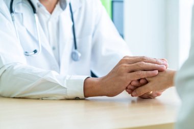 Kıdemli doktor kadın hastasını güven verici el