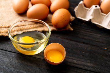 Ahşap masa üzerinde yumurta ile bir kırık kahverengi ve yumurta sarısı