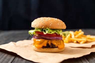 taze lezzetli biftek burger peynir ve patates kızartması ahşap arka plan üzerinde