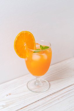 Buzlu bir bardak portakal suyu.