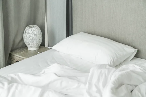 white pillow on bed and with wrinkle messy blanket in bedroom