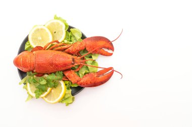 Beyaz arka planda taze haşlanmış sebze ve limonlu ıstakoz.
