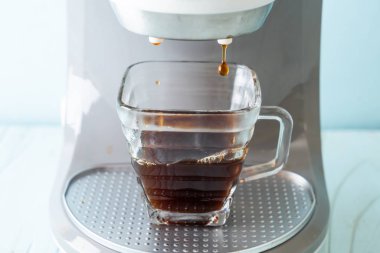 Kahve makinesi ahşap arka planda kahve yapıyor.