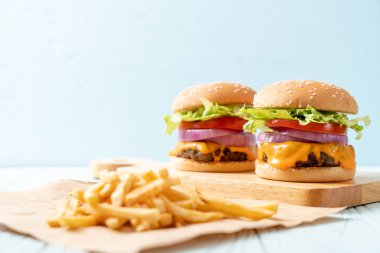 taze lezzetli biftek burger peynir ve patates kızartması ahşap arka plan üzerinde