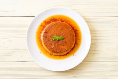 Ev yapımı karamel kremalı puding ahşap arka plan üzerinde