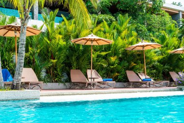 Şemsiye ve sandalye yüzme havuzunda otel ve tatil - tatil tatil kavramı çevresinde