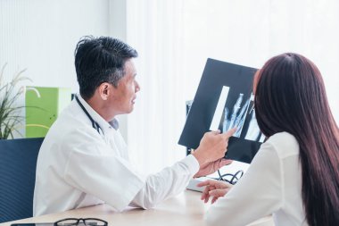 Asyalı doktor ve hasta röntgen film Office ile görüşüyorlar
