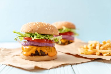 taze lezzetli biftek burger peynir ve patates kızartması ahşap arka plan üzerinde