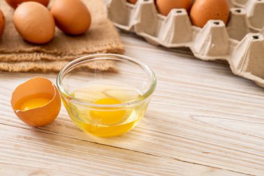 Ahşap masa üzerinde yumurta ile bir kırık kahverengi ve yumurta sarısı