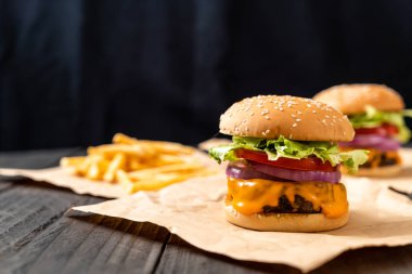 taze lezzetli biftek burger peynir ve patates kızartması ahşap arka plan üzerinde