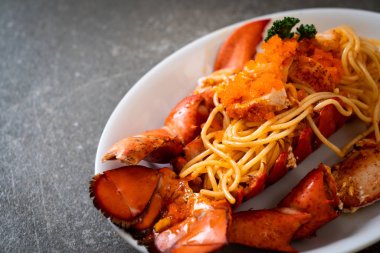 Beyaz tabakta karides yumurtalı ıstakoz spagettisi.