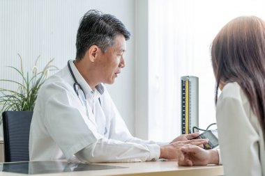 Asya kıdemli doktor ve hasta bir şey masada otururken görüşüyorlar