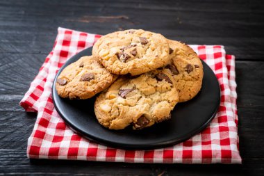 Tabağında çikolata parçaları olan kurabiyeler.