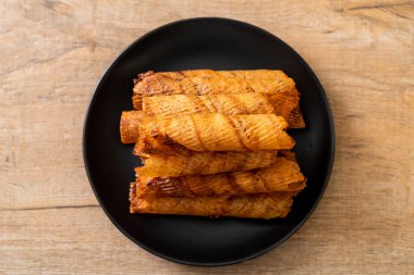 Çıtır çıtır kurutulmuş kalamar ruloları tabakta.