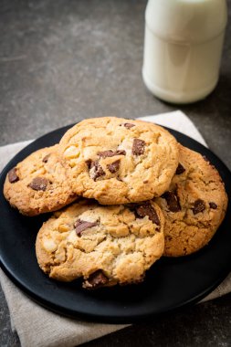 Tabağında çikolata parçaları olan kurabiyeler.