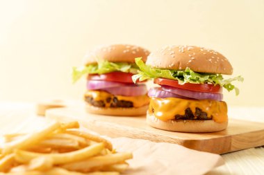 taze lezzetli biftek burger peynir ve patates kızartması ahşap arka plan üzerinde