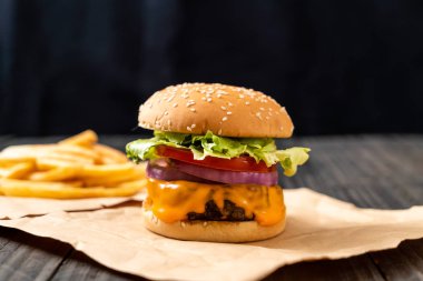 taze lezzetli biftek burger peynir ve patates kızartması ahşap arka plan üzerinde