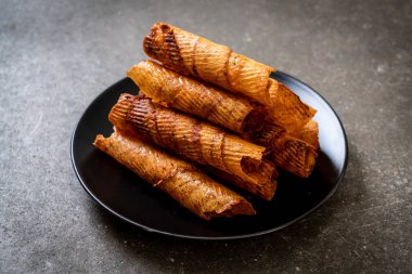 Çıtır çıtır kurutulmuş kalamar ruloları tabakta.