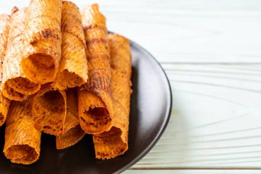 Çıtır çıtır kurutulmuş kalamar ruloları tabakta.