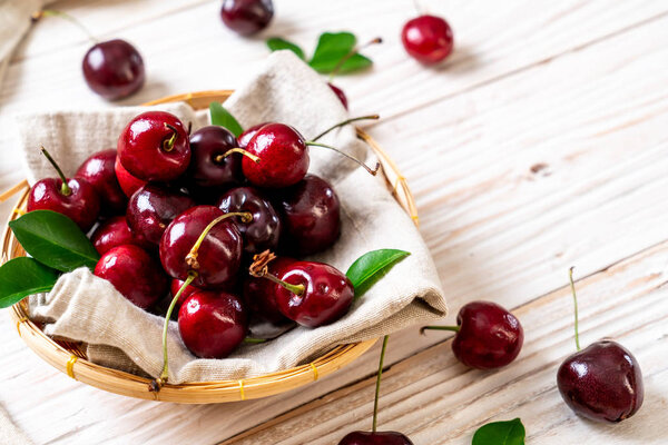 Fresh cherries in bowl  on wood background