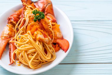 Beyaz tabakta karides yumurtalı ıstakoz spagettisi.