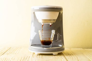 Kahve makinesi ahşap arka planda kahve yapıyor.