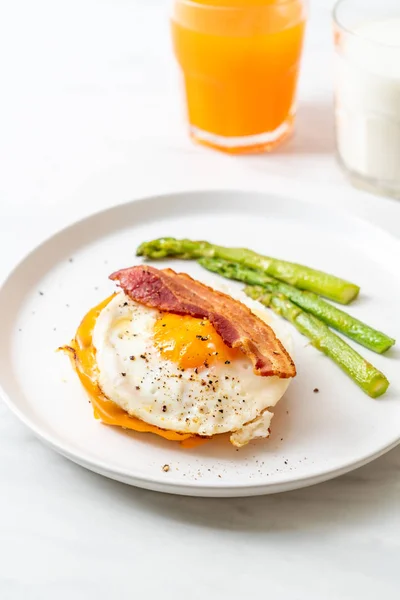 fried egg with bacon and cheese on pancake for breakfast