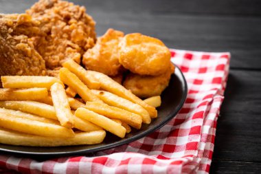 Kızarmış tavuk, patates kızartması ve nugget yemeği. Abur cubur ve sağlıksız yemek.
