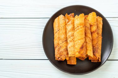 Çıtır çıtır kurutulmuş kalamar ruloları tabakta.