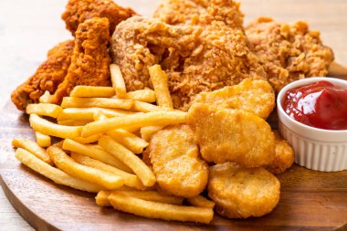 Kızarmış tavuk, patates kızartması ve nugget yemeği. Abur cubur ve sağlıksız yemek.
