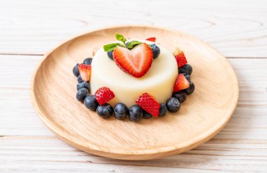 yoğurt puding plaka üzerinde bir yaban mersini ve taze çilek ile