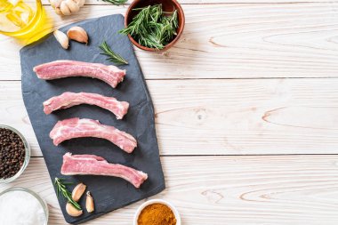 Taze Çiğ domuz kaburga üzerinde kara tahta malzemelerle