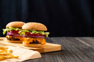 taze lezzetli biftek burger peynir ve patates kızartması ahşap arka plan üzerinde