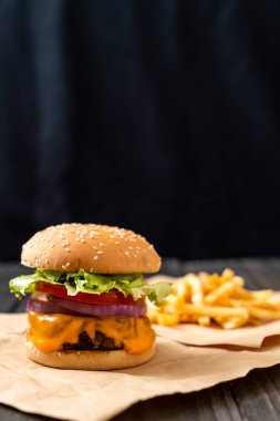 taze lezzetli biftek burger peynir ve patates kızartması ahşap arka plan üzerinde