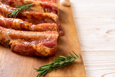 Tahtadaki malzemelerle birlikte kızartılmaya hazır taze çiğ domuz pirzolası.