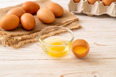 Ahşap masa üzerinde yumurta ile bir kırık kahverengi ve yumurta sarısı