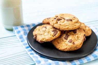 Tabağında çikolata parçaları olan kurabiyeler.