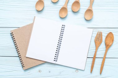 metin Not ahşap yüzey ve tahta kaşık ve çatal ile kopya sapce için boş defter