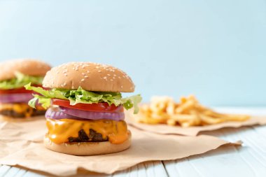 taze lezzetli biftek burger peynir ve patates kızartması ahşap arka plan üzerinde